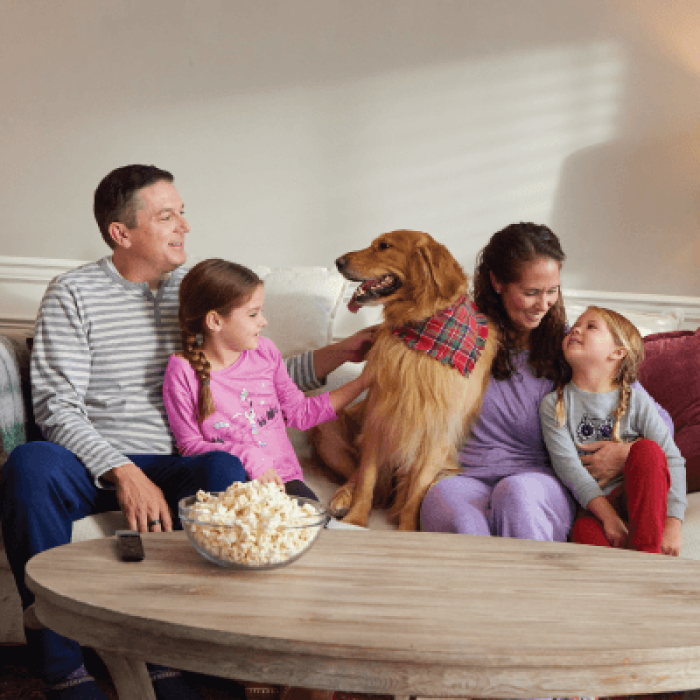 family with dog relaxing on couch